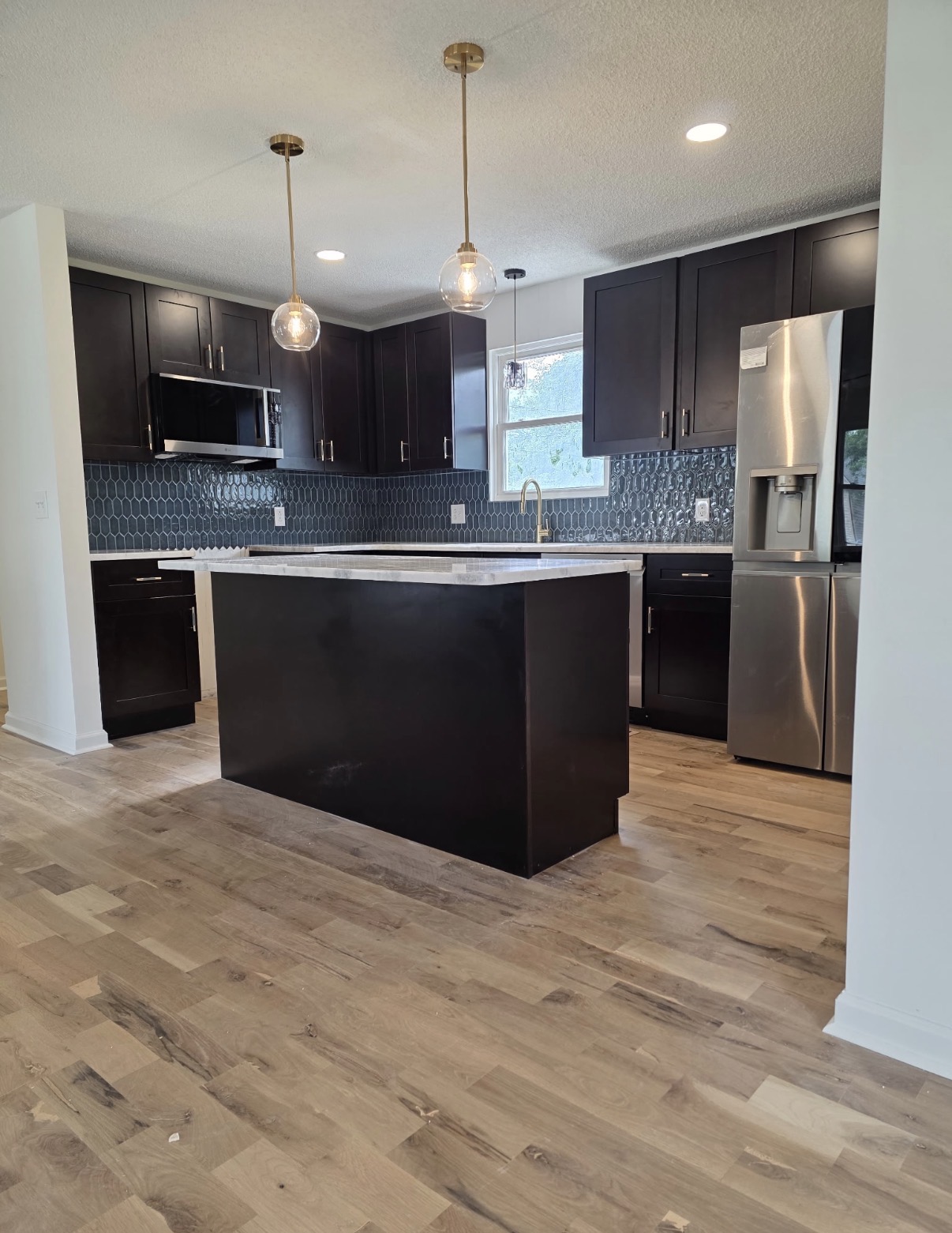 A completed kitchen with dark cabinetry and a large island
