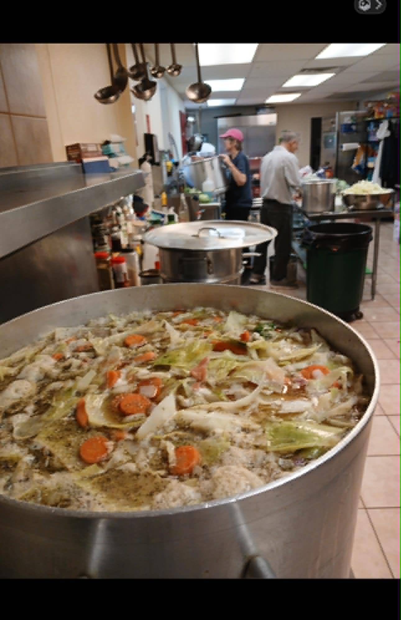 Large pots of food being prepared in a commercial kitchen for community outreach